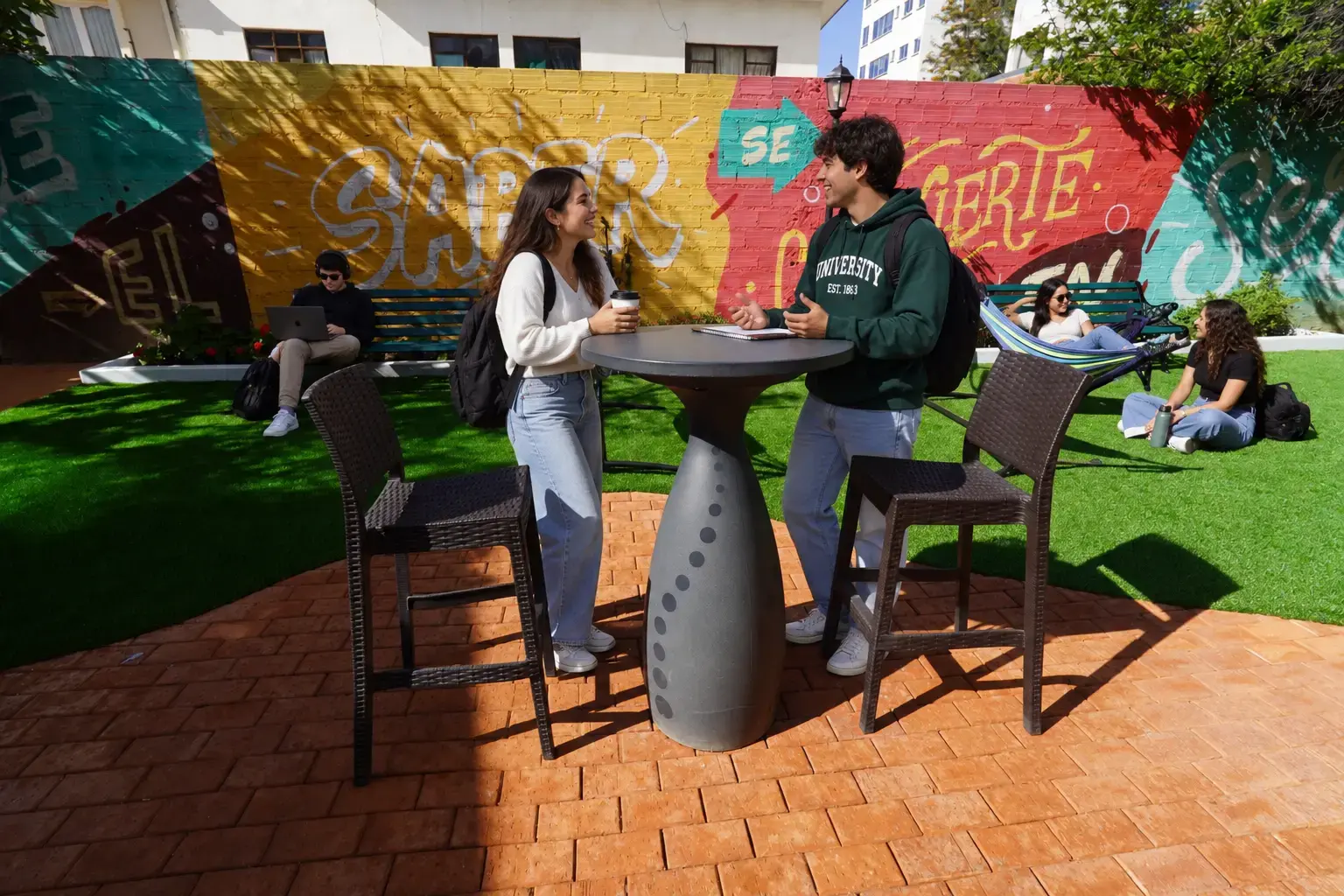 Estudiantes conversando en los jardines del Campus Túpac Amaru