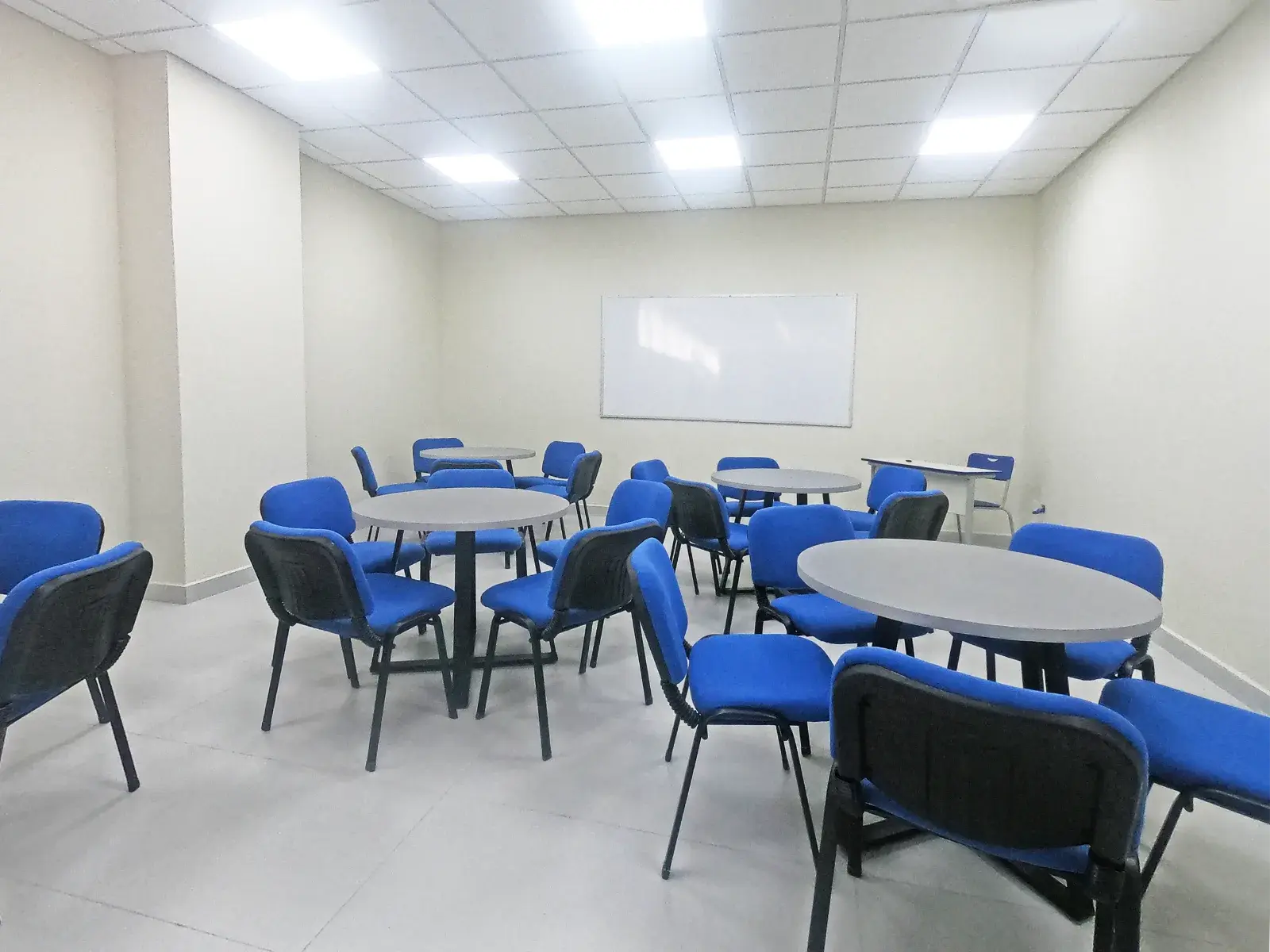 Sala de negocios del Campus Soria Galvarro con mesas redondas y sillas azules