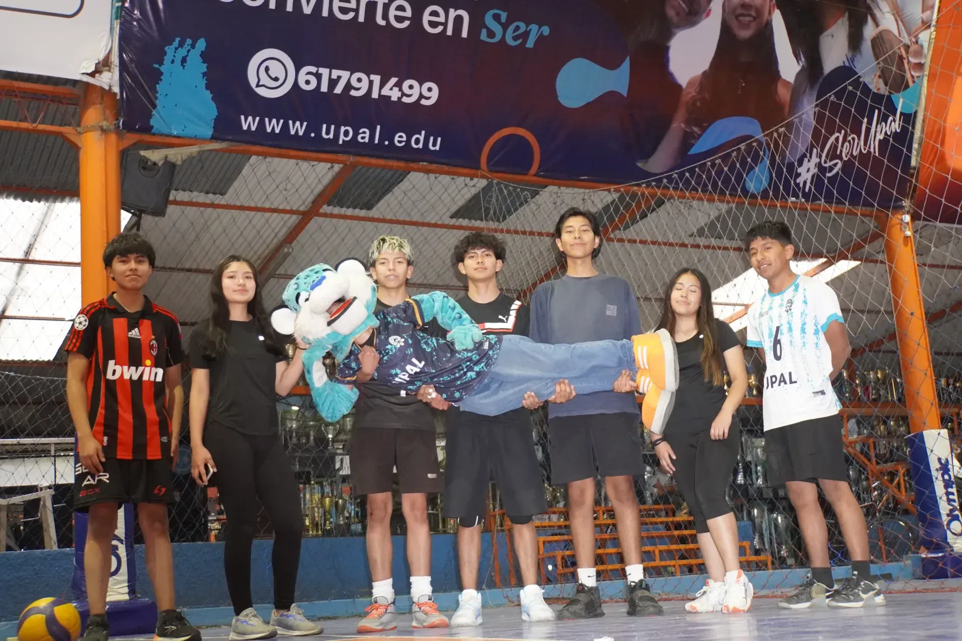 Estudiantes del club de voleibol cargando a la mascota jaguar